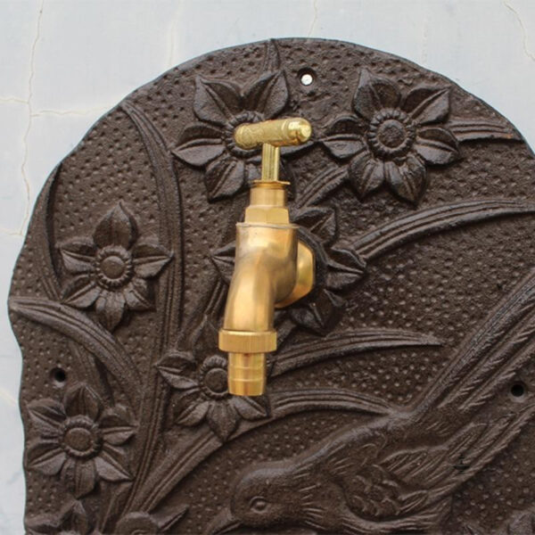 Détail d'une fontaine murale vintage en fonte